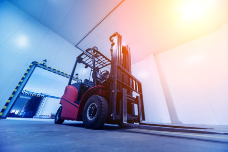 Forklift in a large industrial freezer warehouse. Empty warehouse for vegetable storage. Background