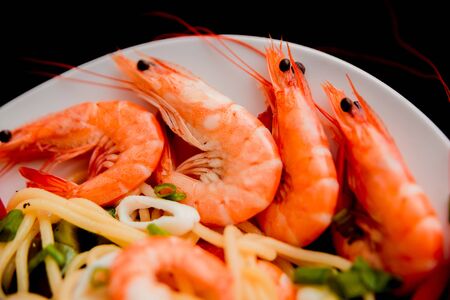 Shrimp and squid with pasta on a white plate. restaurantの写真素材
