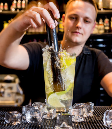 Bartender is making cocktail at bar counter. Fresh cocktails. Barman at work.