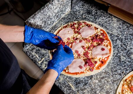 The process of making pizza. Hands of chef baker making pizza at cafe kitchen. Restaurantの写真素材