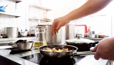 Chef cooks fried potatoes with pieces of meat in a restaurant kitchen. European cuisine. Backgroundの写真素材