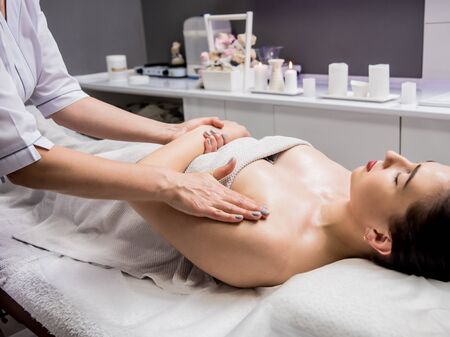 Beautiful young woman enjoying massage in spa salon. Cosmetologyの写真素材