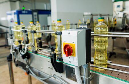 Bottling line of sunflower oil in bottles. Vegetable oil production plant. High technology. Industrial backgroundの写真素材