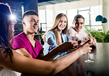 Cheerful friends in the pub. Drinking beer, wine and whisky
