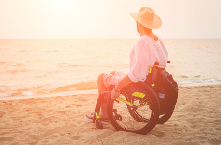 Disabled man in a wheelchair on the beach. Concept background