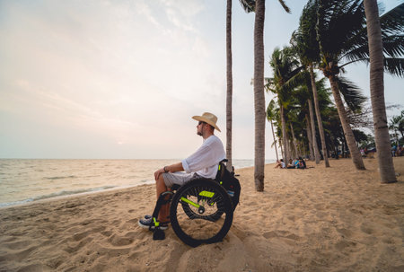 Disabled man in a wheelchair on the beach.