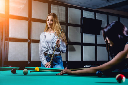 Young woman trying to hit the ball in billiard.