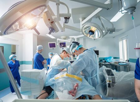 Spinal surgery. Group of surgeons in operating room with surgery equipment.の写真素材