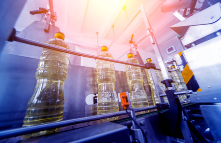 Bottling line of sunflower oil in bottles. Vegetable oil production plant