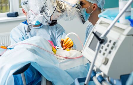 Brain surgery. Group of surgeons in operating room with surgery equipment. Modern medical backgroundの写真素材