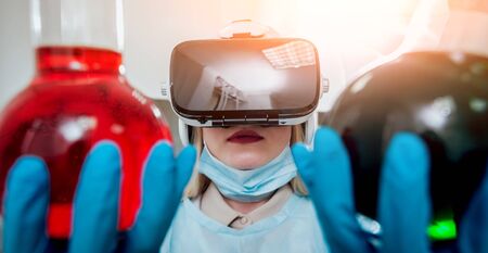 Science technician in virtual reality glasses examines the drug in laboratory.の写真素材