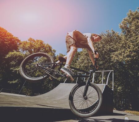 Bmx rider performing tricks at skatepark. Backgroundの写真素材