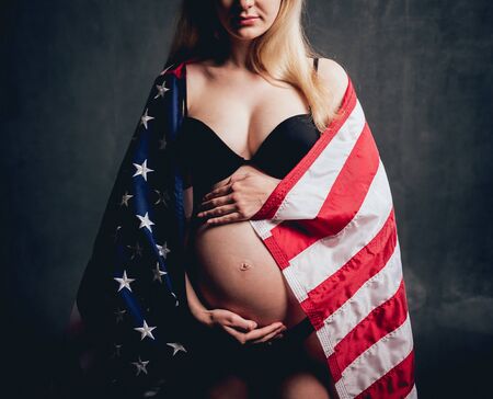 Pregnant woman with american flag. Studio shootingの写真素材