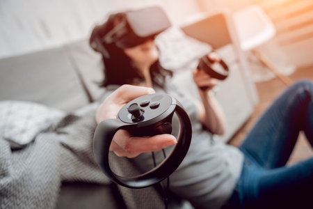 The beautiful girl playing games with virtual reality goggles