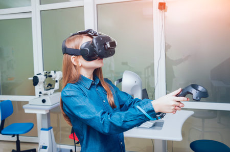 Eye treatment. Patient in virtual reality goggles. Checking the girl's vision with the help of...