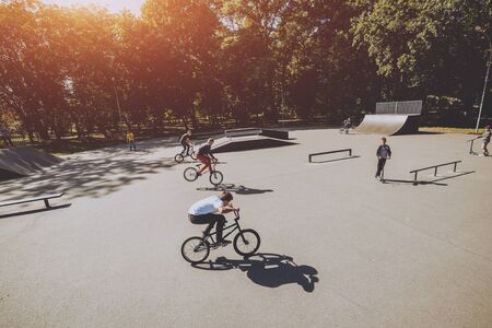 Bmx riders performing tricks at skatepark. Outdoors.の写真素材