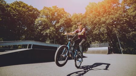 Bmx rider performing tricks at skatepark. Backgroundの写真素材