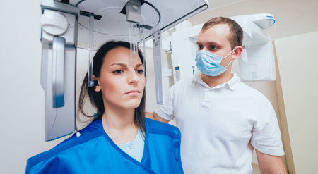 Young woman patient standing in x-ray machine.
