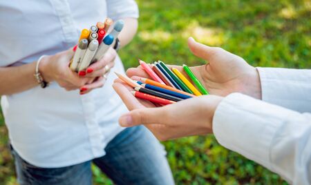 Girl holding many colorful wooden pencils in the hands.の写真素材