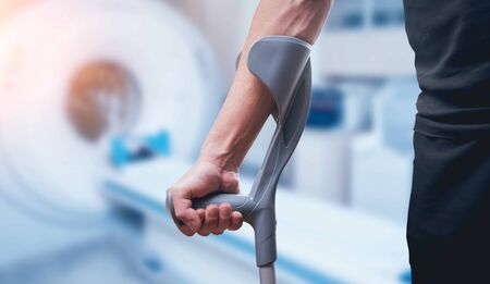 Injured man trying to walk on crutches. Blurred backgroundの写真素材