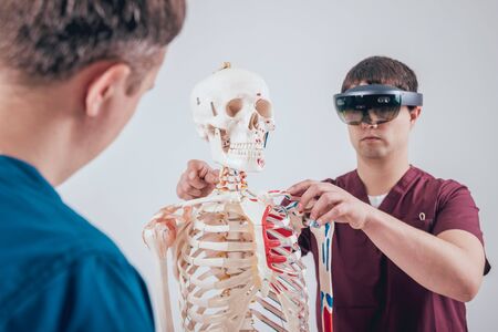 Doctor uses augmented reality goggles and human skeletonの写真素材