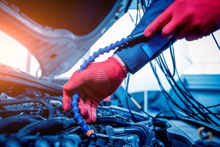 Auto mechanic uses a voltmeter to check the voltage level.の写真素材