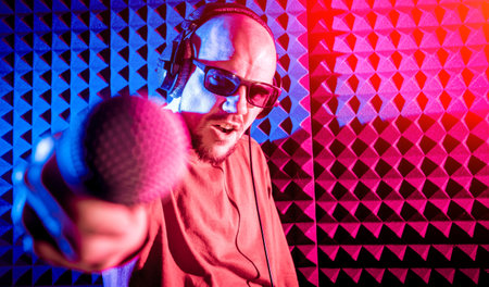 The singer sings with a microphone in the recording studio.