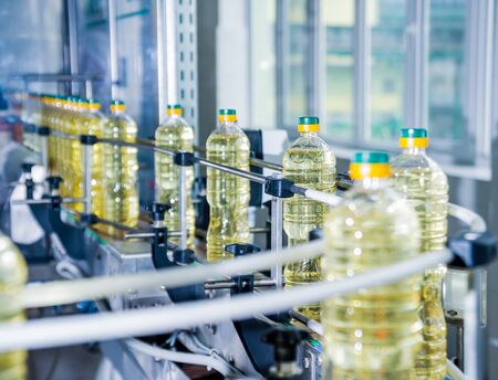 Bottling line of sunflower oil in bottles. Vegetable oil production plant. High technology. Industrial backgroundの写真素材