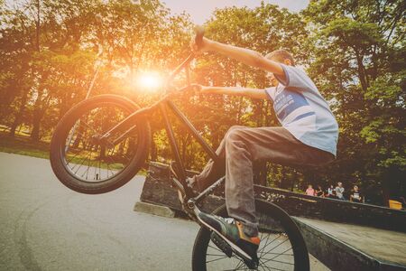 Boy riding a bmx in a park. Beautiful backgroundの写真素材
