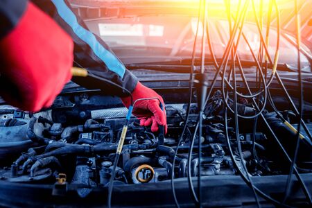 Auto mechanic uses a voltmeter to check the voltage level.の写真素材