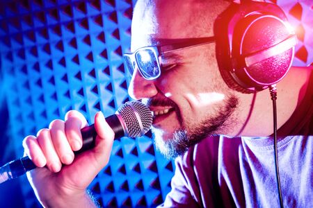 The singer sings with a microphone in the recording studio.の写真素材