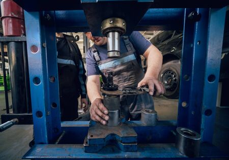Car mechanic press new silentblock at repair service station. Auto service.の写真素材