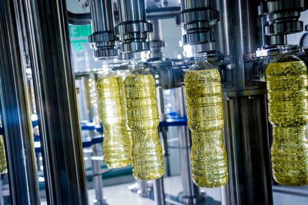 Bottling line of sunflower oil in bottles. Vegetable oil production plant.の写真素材