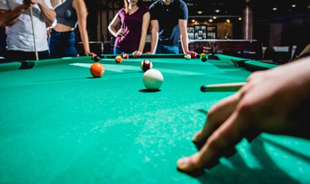 Young man trying to hit the ball in billiard.の写真素材