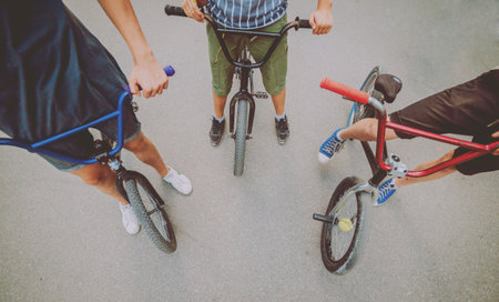 Company of young people on BMX. Beautiful background