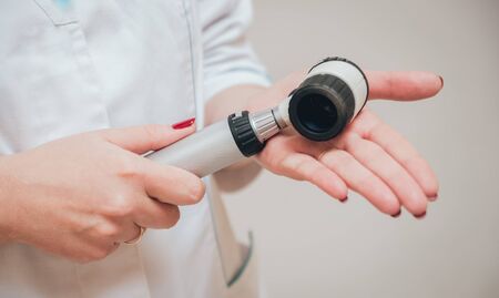 Dermatologist with dermatoscope. Medical equipment. Light Backgroundの写真素材