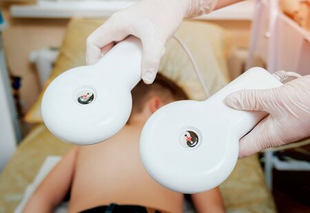 Treatment and warming-up the back of a young boy. Modern Pediatrics. Physiotherapyの写真素材