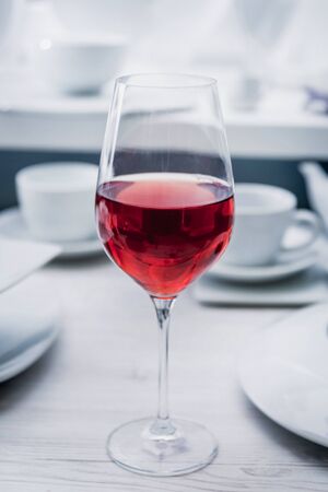 Red wine in a glass at restaurant. Light backgroundの写真素材