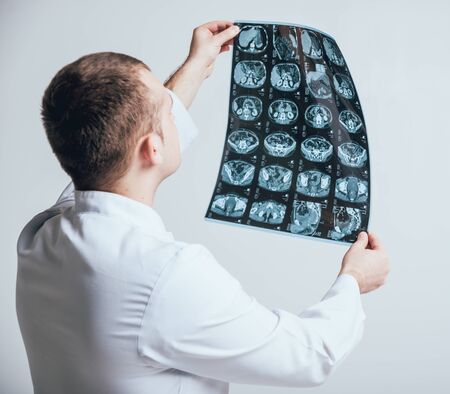 Doctor attentively examines the MRI scan of the patient.の写真素材