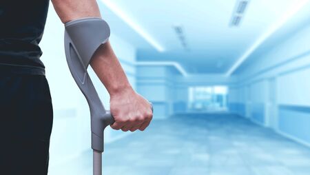 Injured man trying to walk on crutches.の写真素材
