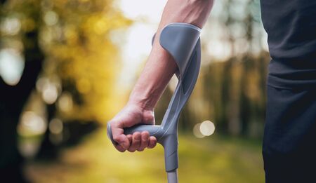 Injured man trying to walk on crutches.の写真素材