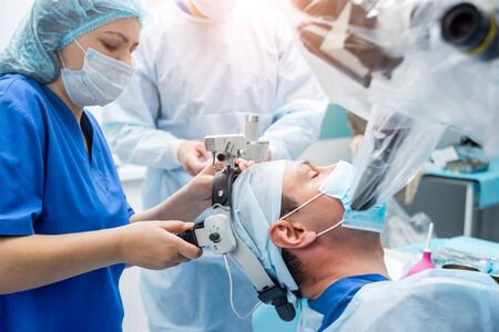 Brain surgery. Group of surgeons in operating room with surgery equipment. Modern medical backgroundの写真素材