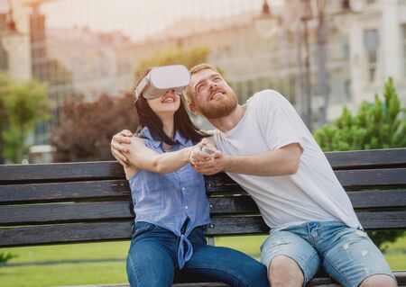 A young couple plays a game using virtual reality glasses on the street.の写真素材