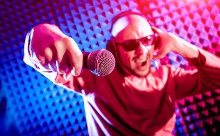The singer sings with a microphone in the recording studio.の写真素材