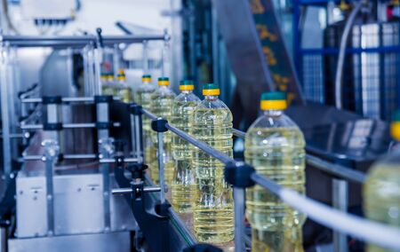 Bottling line of sunflower oil in bottles. Vegetable oil production plant.の写真素材