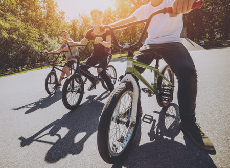 Bmx riders performing tricks at skatepark. Background