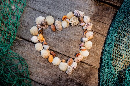 Heart of seashells. Background of a fishing netの写真素材