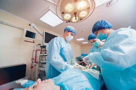 Group of surgeons in operating room with surgery equipment.の写真素材