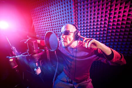 The singer sings with a microphone in the recording studio. Modern backgroundの写真素材