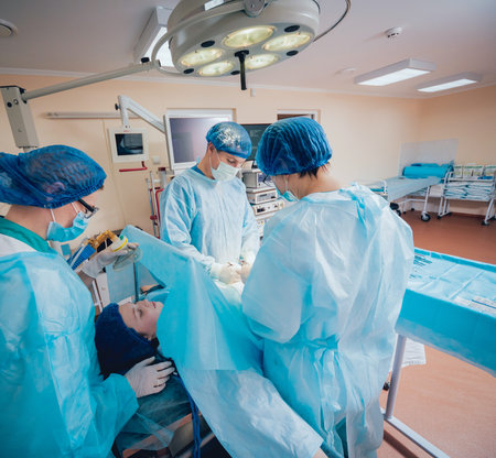 Group of surgeons in operating room with surgery equipment. Background